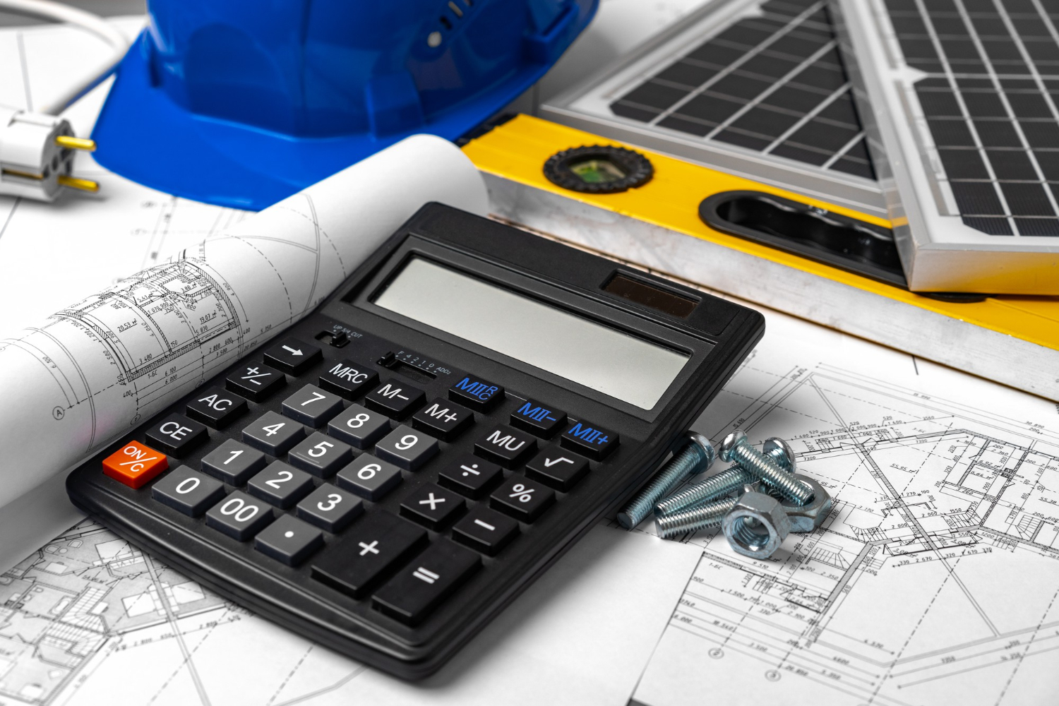 Plans de construction casque et batterie solaire sur la table des architectes